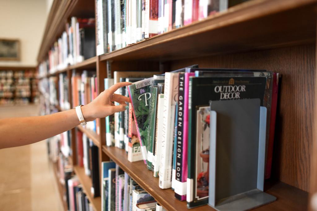 Image of Person Holding Book from Shelf